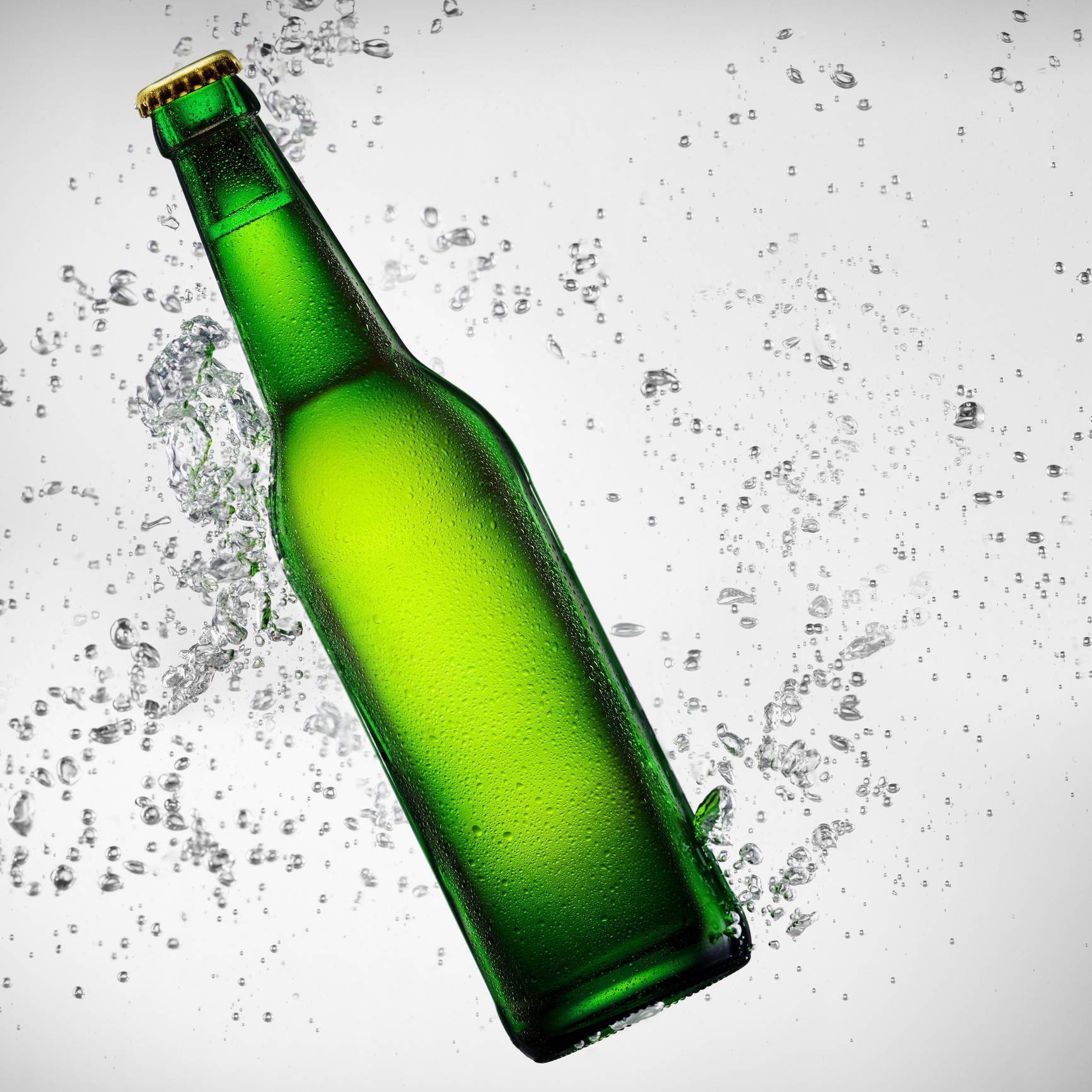 Green bottle of beer falling into water