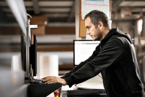 Man working at printer control console