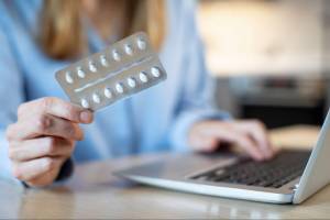 woman holding blister pack of medicine